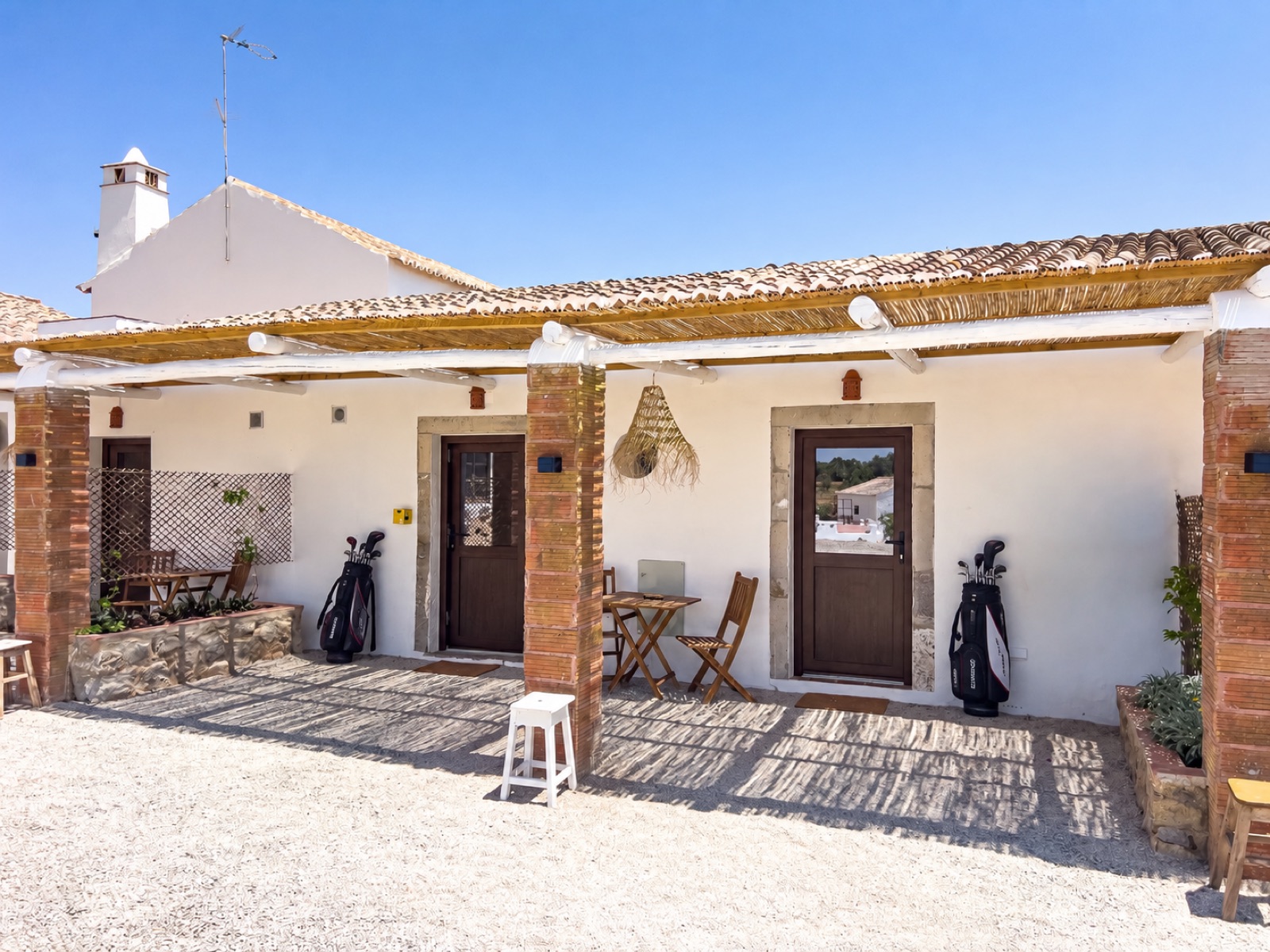 porch with a reed pergola and golf bags by the door